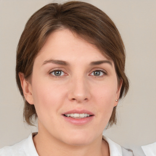 Joyful white young-adult female with medium  brown hair and grey eyes