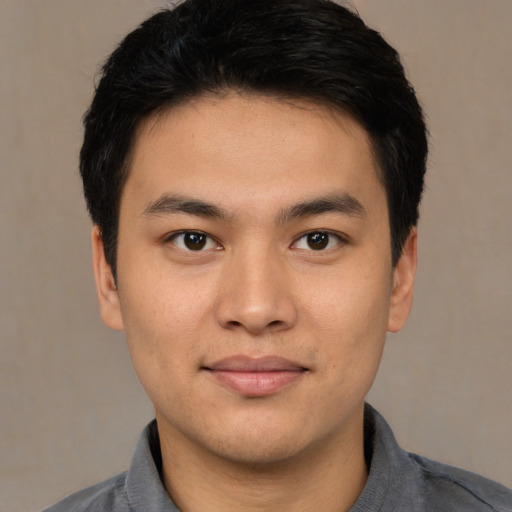 Joyful asian young-adult male with short  brown hair and brown eyes