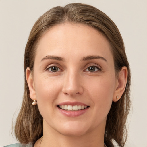 Joyful white young-adult female with medium  brown hair and grey eyes