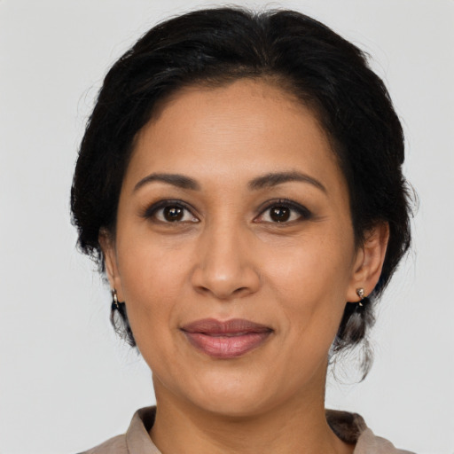 Joyful latino adult female with medium  brown hair and brown eyes