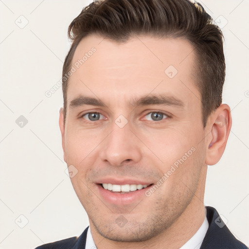 Joyful white young-adult male with short  brown hair and brown eyes