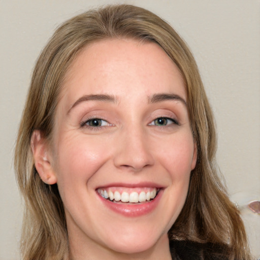 Joyful white young-adult female with long  brown hair and green eyes