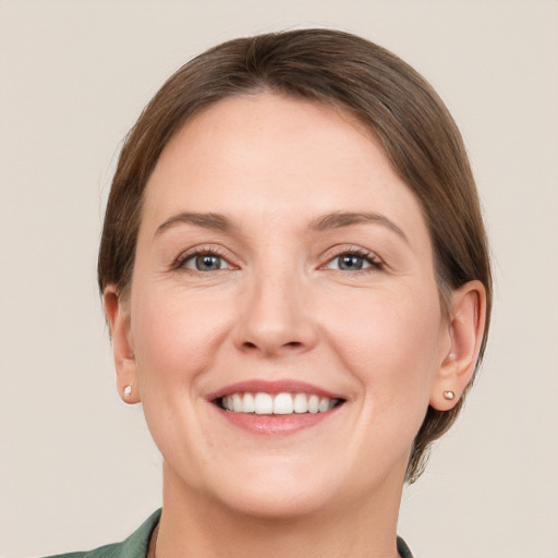 Joyful white young-adult female with short  brown hair and grey eyes