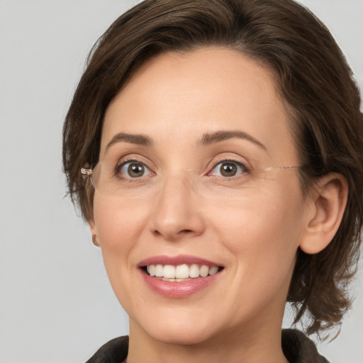 Joyful white adult female with medium  brown hair and grey eyes