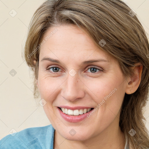 Joyful white adult female with medium  brown hair and blue eyes