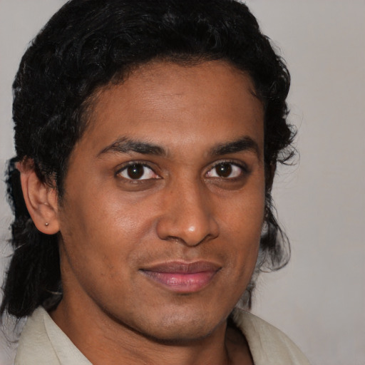 Joyful black young-adult male with short  brown hair and brown eyes