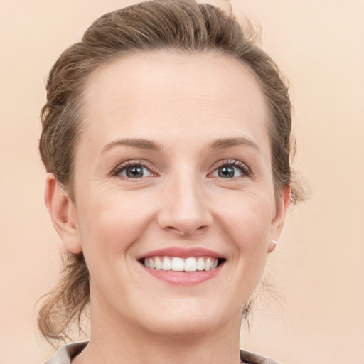 Joyful white young-adult female with medium  brown hair and grey eyes