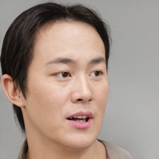 Joyful asian young-adult male with medium  brown hair and brown eyes