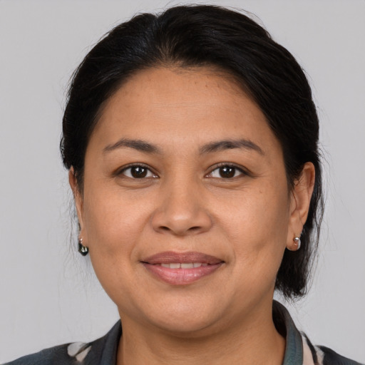 Joyful latino adult female with medium  brown hair and brown eyes