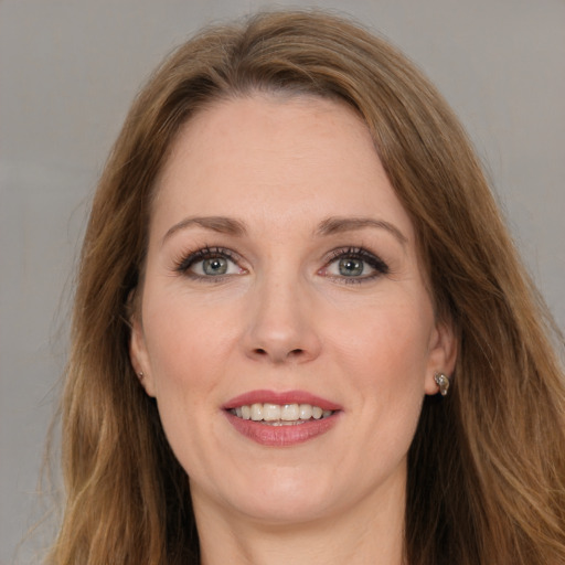 Joyful white adult female with long  brown hair and grey eyes