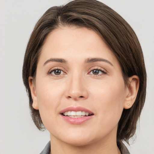 Joyful white young-adult female with medium  brown hair and brown eyes