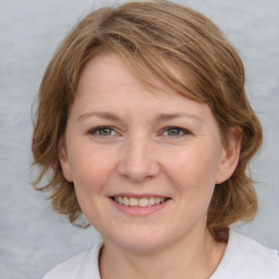 Joyful white young-adult female with medium  brown hair and blue eyes