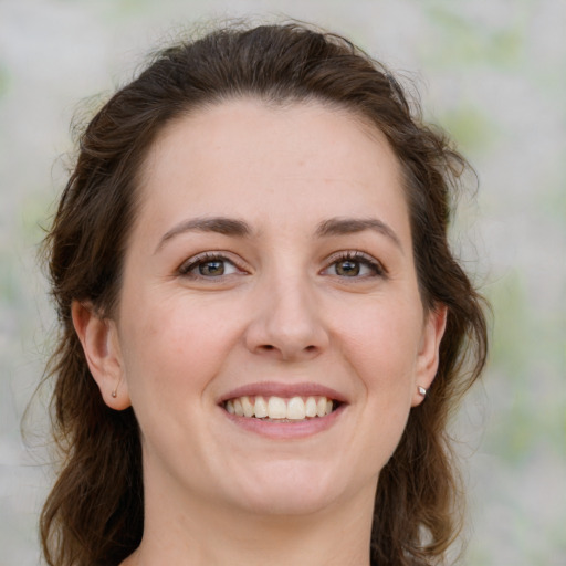 Joyful white young-adult female with medium  brown hair and green eyes