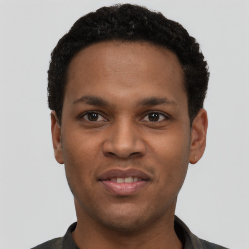 Joyful black young-adult male with short  black hair and brown eyes