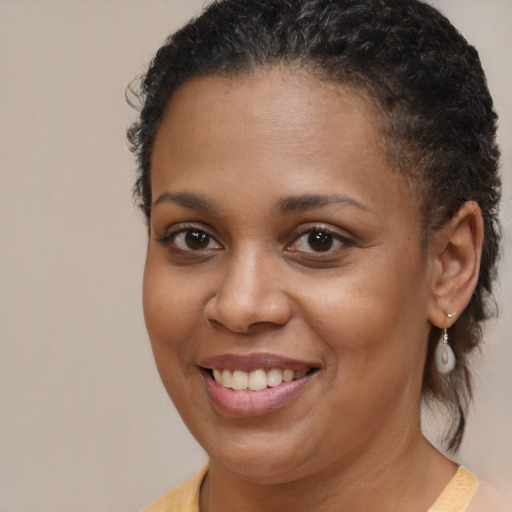 Joyful black young-adult female with short  brown hair and brown eyes