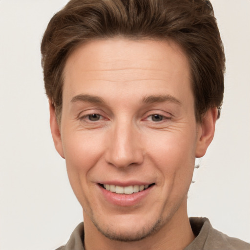 Joyful white adult male with short  brown hair and brown eyes