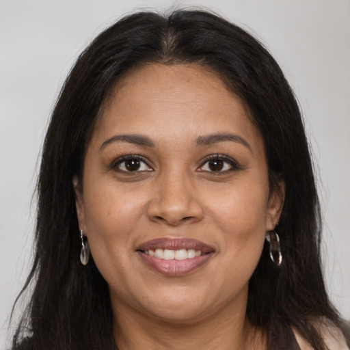 Joyful latino adult female with long  brown hair and brown eyes