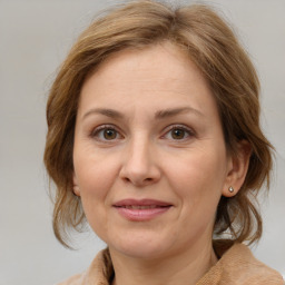 Joyful white adult female with medium  brown hair and blue eyes