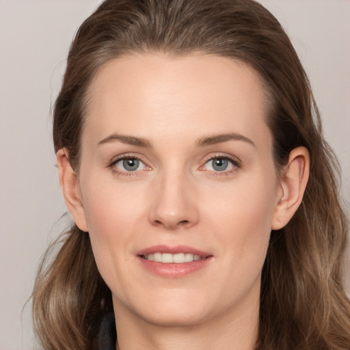 Joyful white young-adult female with long  brown hair and grey eyes