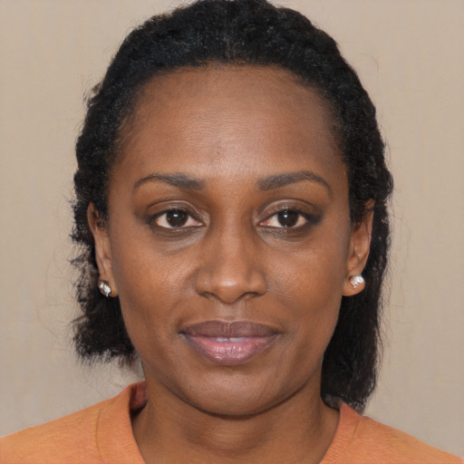 Joyful black adult female with long  brown hair and brown eyes