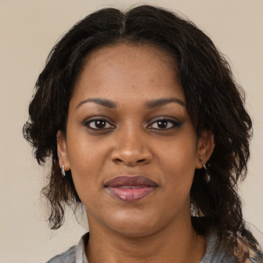 Joyful black adult female with medium  brown hair and brown eyes
