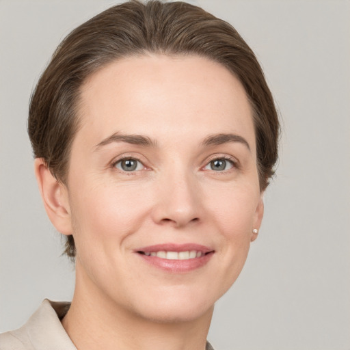 Joyful white young-adult female with short  brown hair and grey eyes