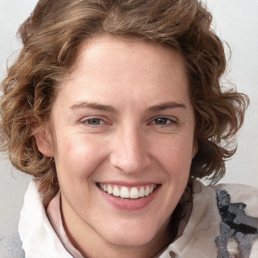 Joyful white young-adult female with medium  brown hair and blue eyes