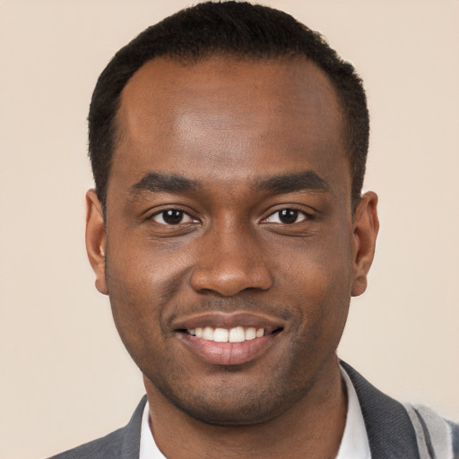 Joyful black young-adult male with short  brown hair and brown eyes