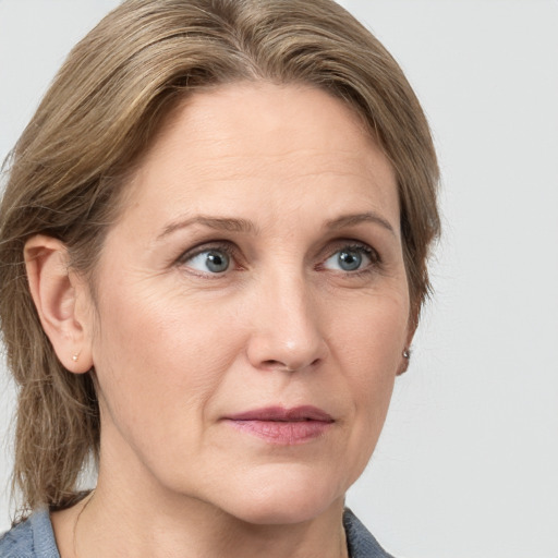 Joyful white adult female with medium  brown hair and grey eyes