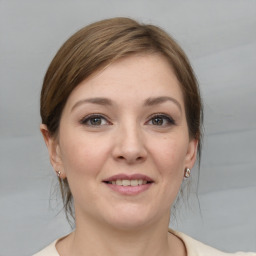 Joyful white young-adult female with medium  brown hair and grey eyes