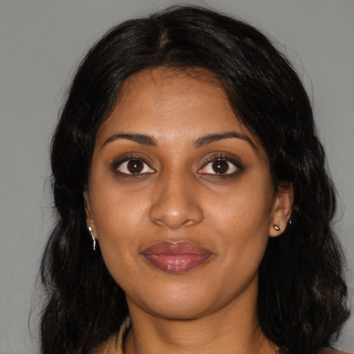 Joyful black young-adult female with long  black hair and brown eyes