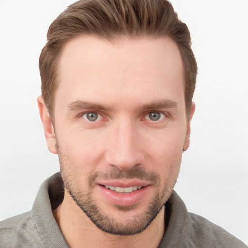 Joyful white young-adult male with short  brown hair and grey eyes