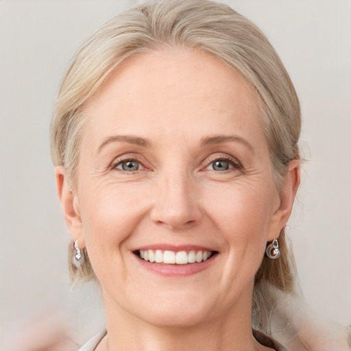 Joyful white adult female with medium  blond hair and grey eyes