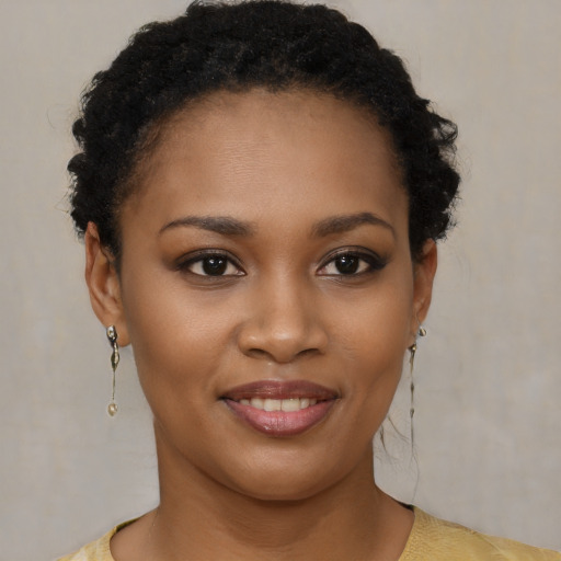 Joyful black young-adult female with short  brown hair and brown eyes