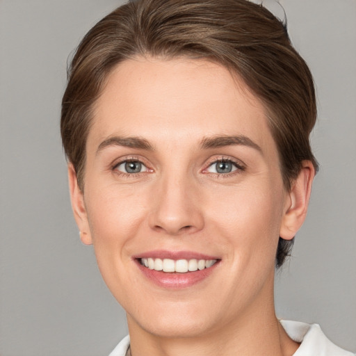 Joyful white young-adult female with short  brown hair and grey eyes