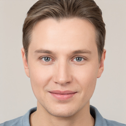 Joyful white young-adult male with short  brown hair and grey eyes