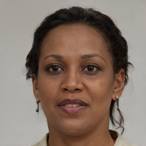 Joyful black adult female with medium  brown hair and brown eyes