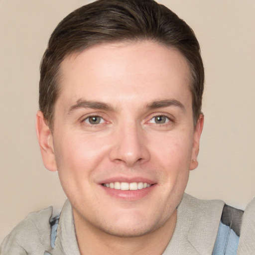 Joyful white young-adult male with short  brown hair and grey eyes