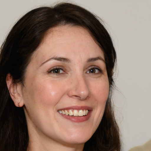 Joyful white adult female with long  brown hair and brown eyes