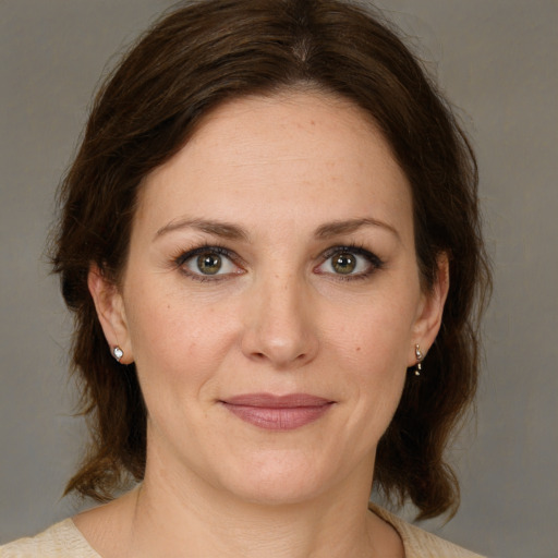 Joyful white adult female with medium  brown hair and brown eyes