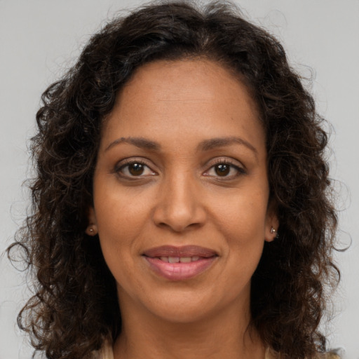Joyful black adult female with long  brown hair and brown eyes