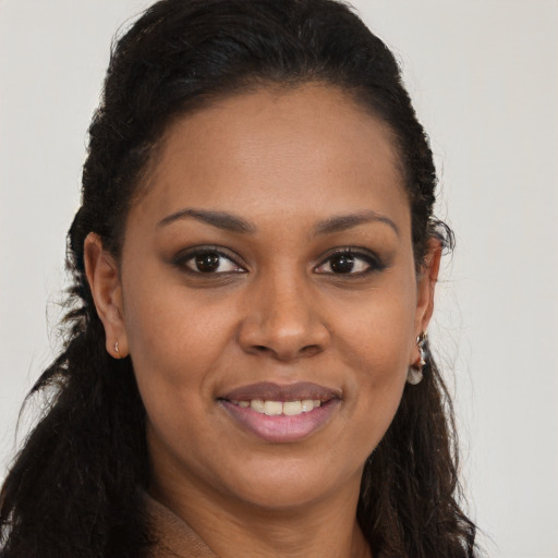 Joyful black young-adult female with long  brown hair and brown eyes