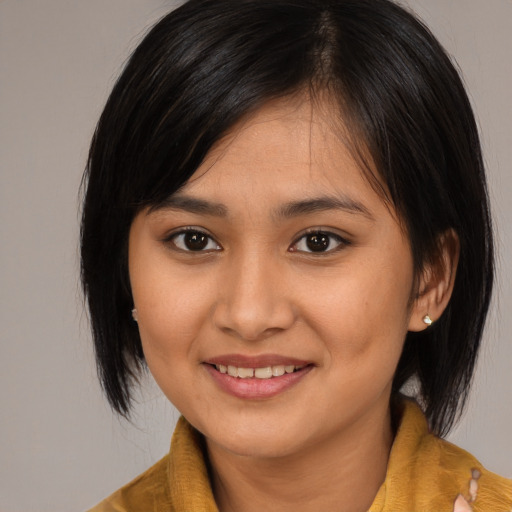 Joyful asian young-adult female with medium  brown hair and brown eyes