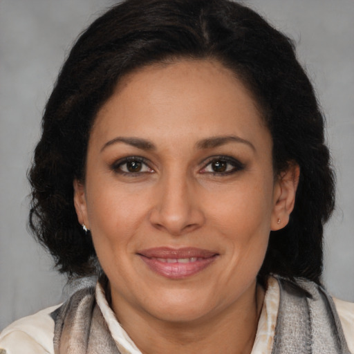 Joyful latino adult female with long  brown hair and brown eyes