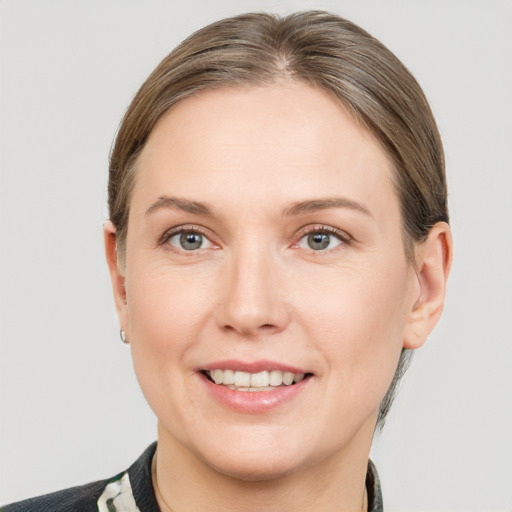 Joyful white young-adult female with medium  brown hair and grey eyes