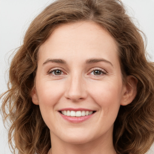 Joyful white young-adult female with long  brown hair and green eyes