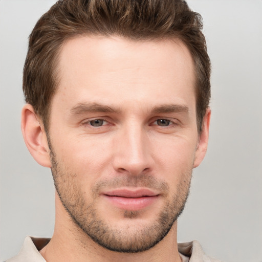 Joyful white young-adult male with short  brown hair and grey eyes