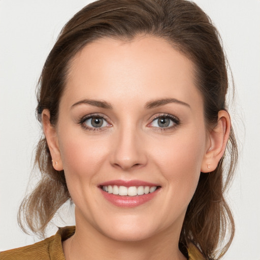 Joyful white young-adult female with medium  brown hair and grey eyes