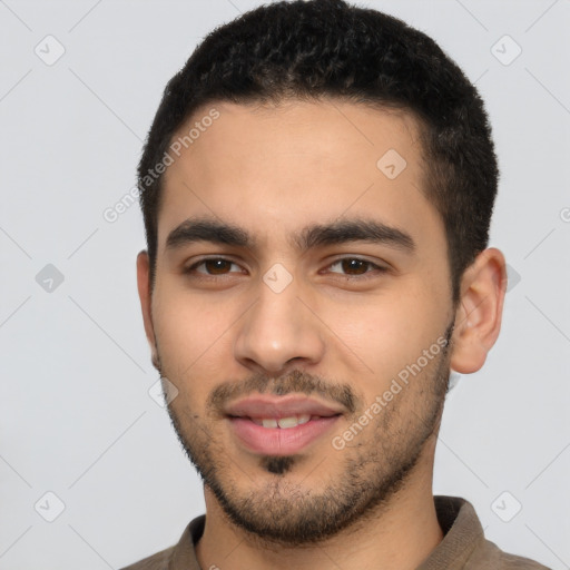 Joyful latino young-adult male with short  black hair and brown eyes