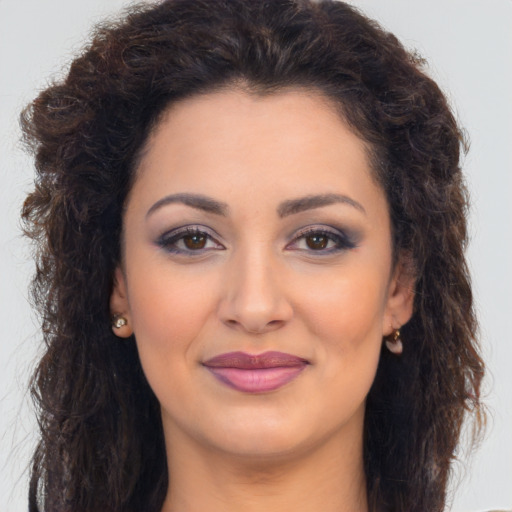 Joyful latino young-adult female with long  brown hair and brown eyes